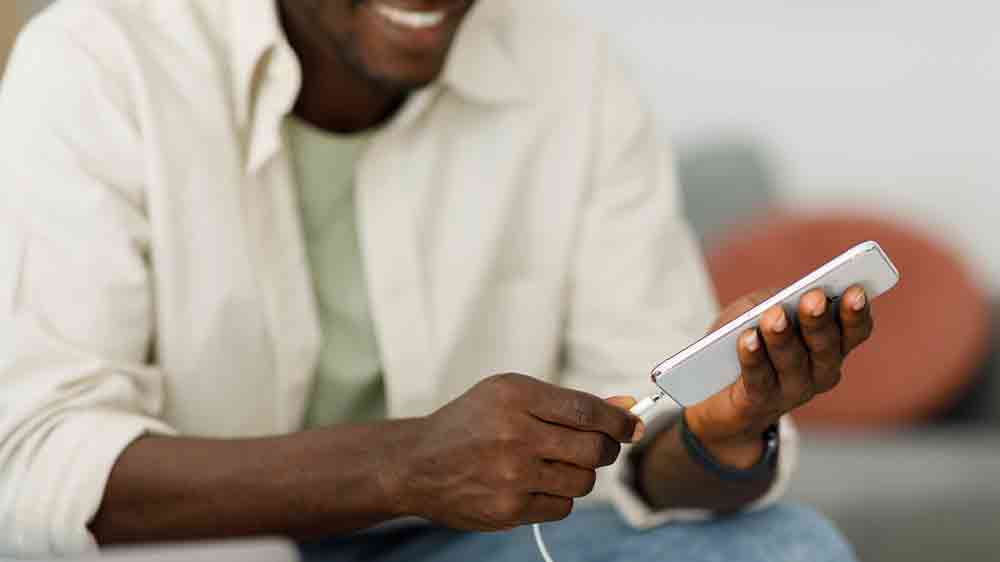 Muž zapojující nabíječku do telefonu_03