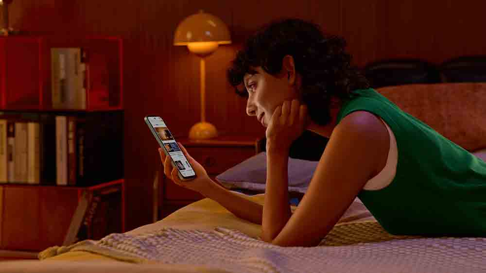 Žena sleduje mobilní telefon Xiaomi Redmi 15 5G_02