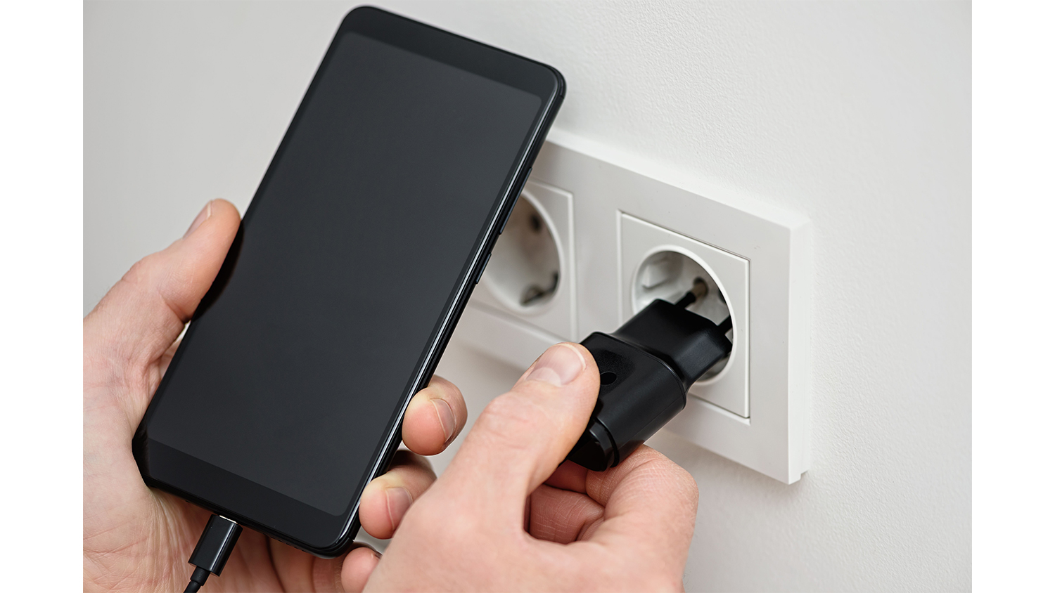 USB-C nabíjačka Yenkee YAC 2033BK čierna pripojená k zásuvke pri nabíjaní smartfónu s bezpečnostnými prvkami