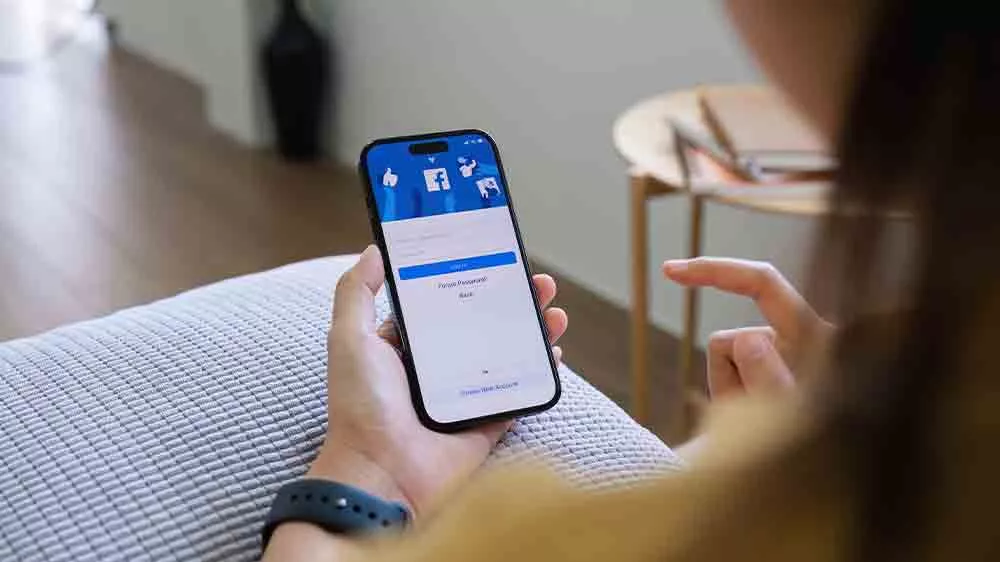 Žena drž&iacute;c&iacute; iPhone v ruce a nastavuj&iacute;c&iacute; Facebook_02