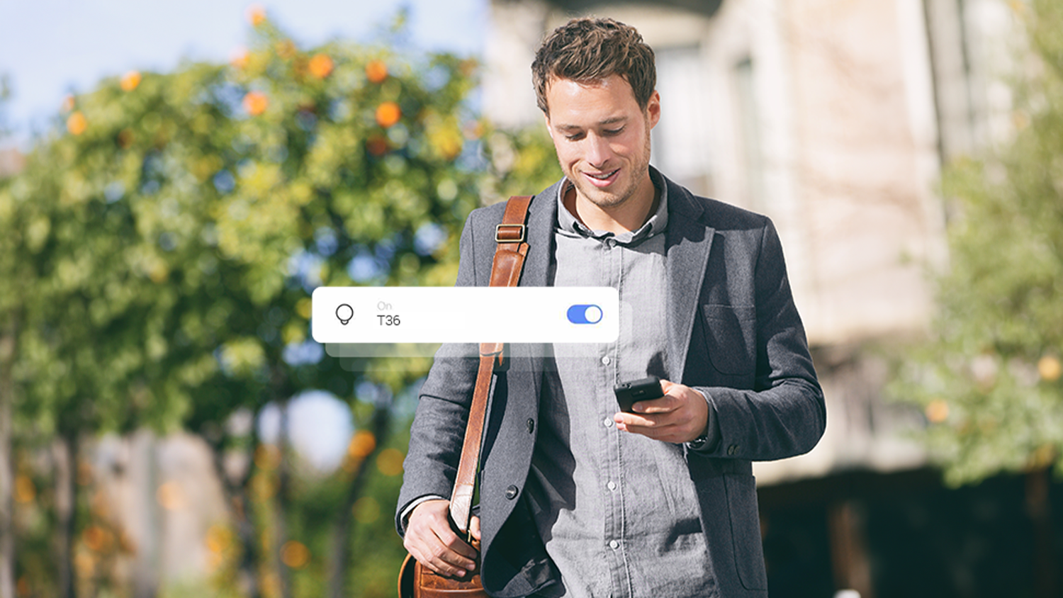 Muž s mobilem v ruce řící světla v domě pomocí aplikace