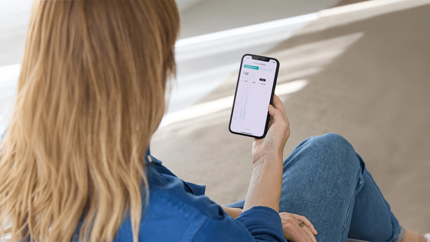 Žena kontroluje spotřebu pomocí aplikace k chytré zásuvce Trust Smart Wi-Fi