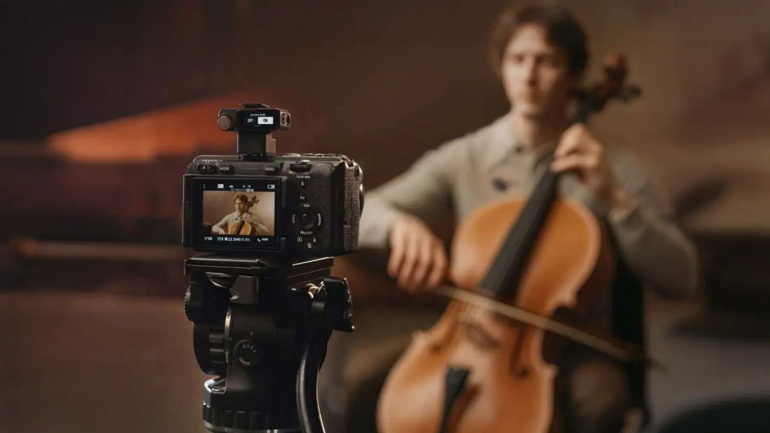 Muž hrajúci na violončelo pred kamerou