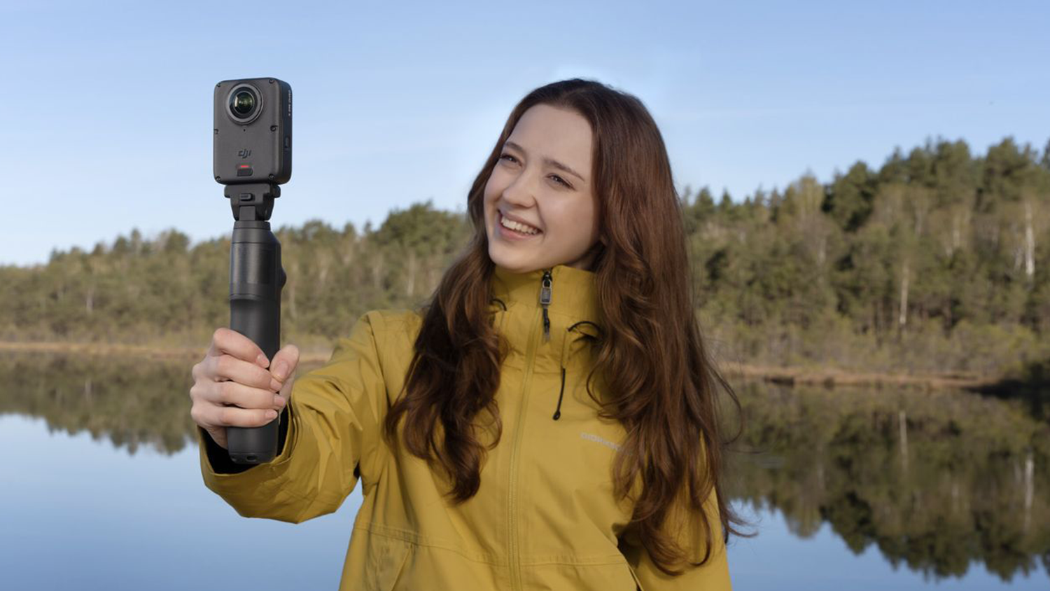 Žena natáčajúca s predlžovacou tyčou s batériou DJI Osmo 360 II