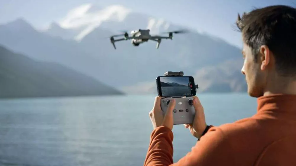 Dron ve velké sadě DJI Air 3S Fly More Combo – Operátor dronu s ovládáním_03