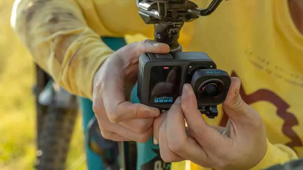 Mužsk&eacute; ruce nasazuj&iacute;c&iacute; objektiv GoPro HB na kameru GoPro upevněnou na r&aacute;mu kola_05