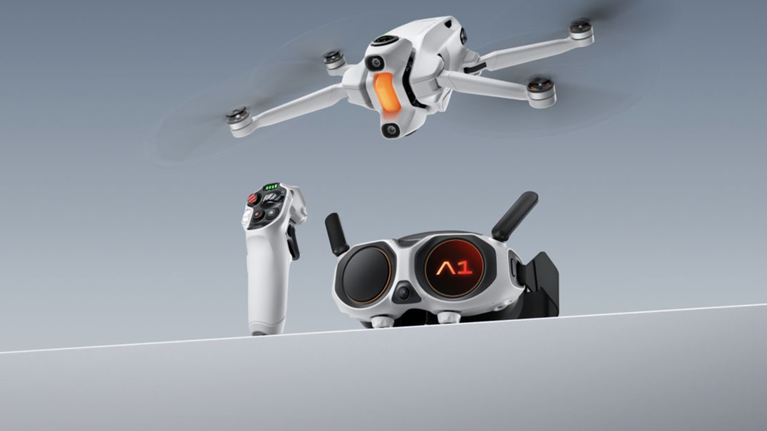 Dron Insta360 a ovladač s brýlemi na bílé ploše
