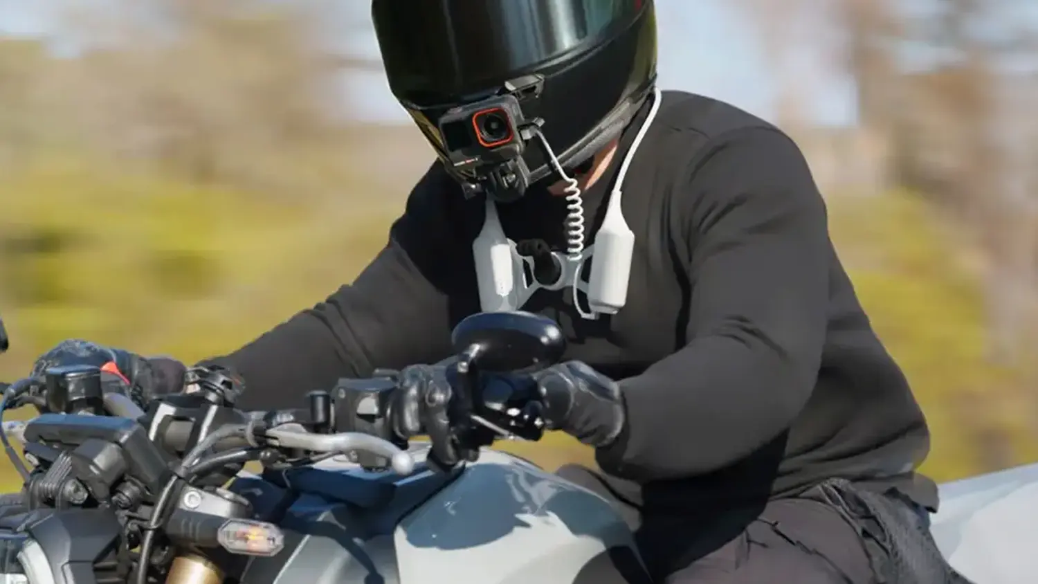 Motork&aacute;ř s nasazen&yacute;m drž&aacute;kem Insta360 FOMO Power Neck Mount