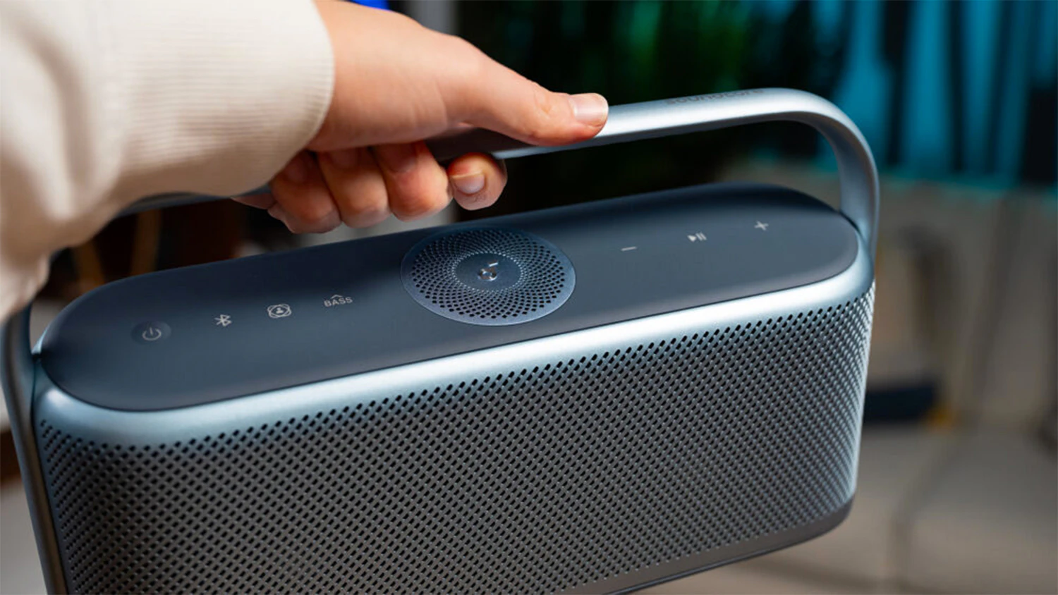 Muž drž&iacute; bezdr&ocirc;tov&yacute; reproduktor Anker Soundcore Motion X600 za rukov&auml;ť