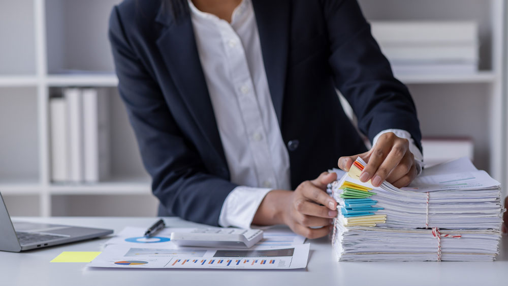 Člověk prohrabuj&iacute;c&iacute; se stohem poti&scaron;těn&yacute;ch pap&iacute;rů_04