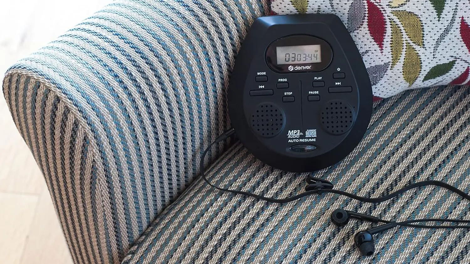 Zapnut&yacute; discman Denver DMP-395B položen&yacute; na křesle.