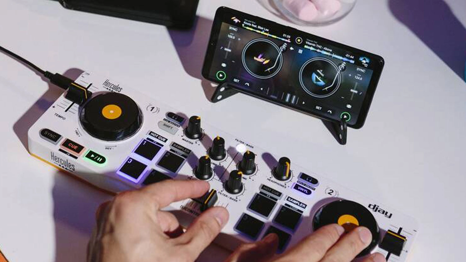 Mužsk&eacute; ruce mixuj&iacute;c&iacute; hudbu na mix&aacute;žn&iacute;m pultu Hercules DJ Control Mix