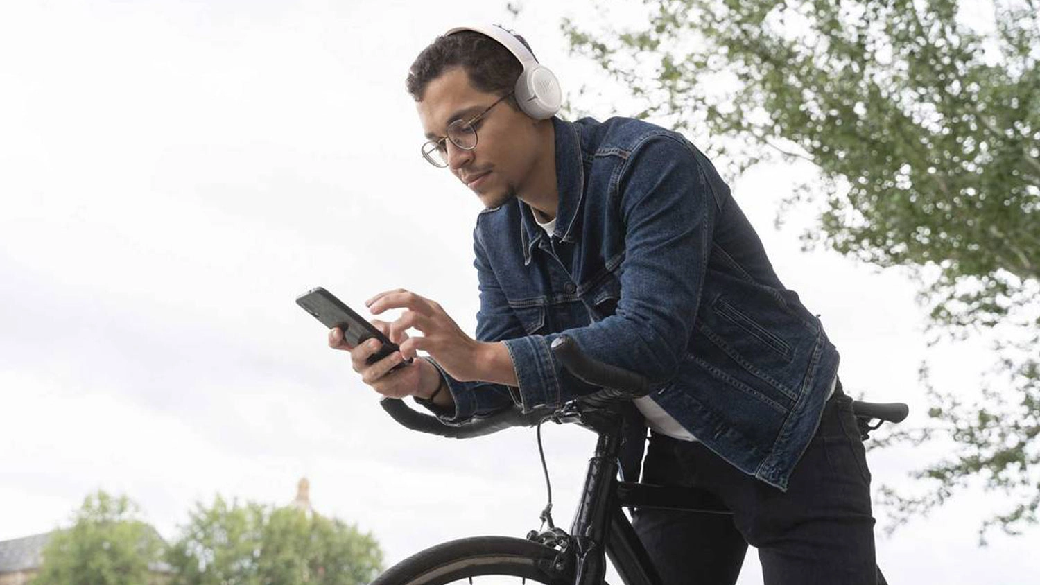 Muž na bicykli so slúchadlami JBL Tune 530BT.