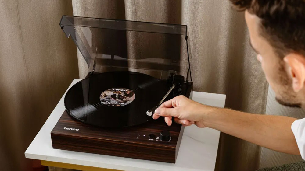 Muž používající gramofon Lenco LS-15WD položený na stole_03