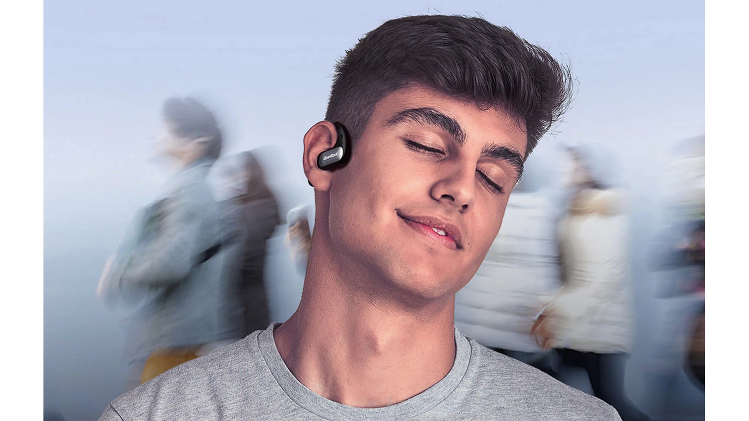 Muž medzi ľuďmi so slúchadlami OneOdio OpenRock Pro