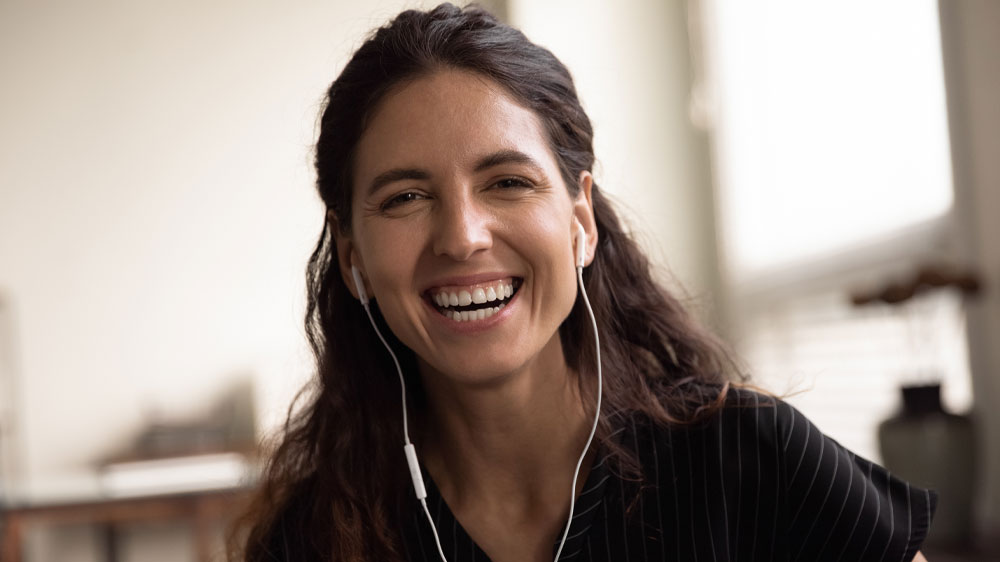 Usmievajúca sa žena so slúchadlami v ušiach_03