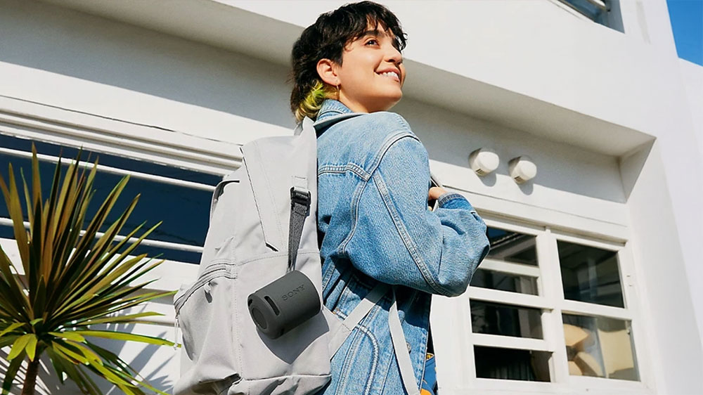 Bezdr&aacute;tov&yacute; reproduktor Sony SRS-XB100 Grey zavě&scaron;en&yacute; na batohu_02