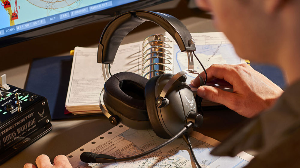 Muž u počítače s herními sluchátky Thrustmaster T.Flight U.S. Air Force Edition na stole_02