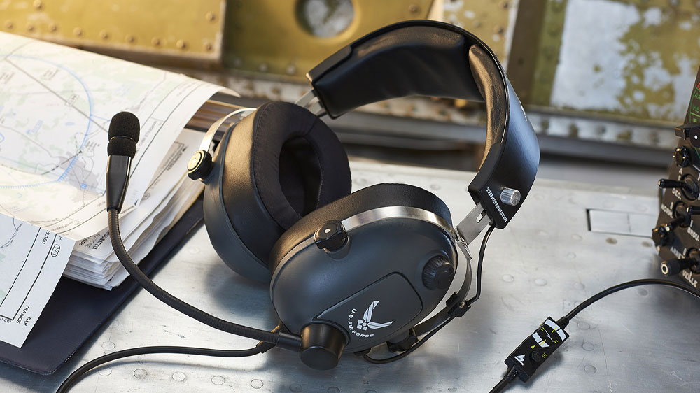 Herní sluchátka Thrustmaster T.Flight U.S. Air Force Edition položená na stole vedle leteckých map_03