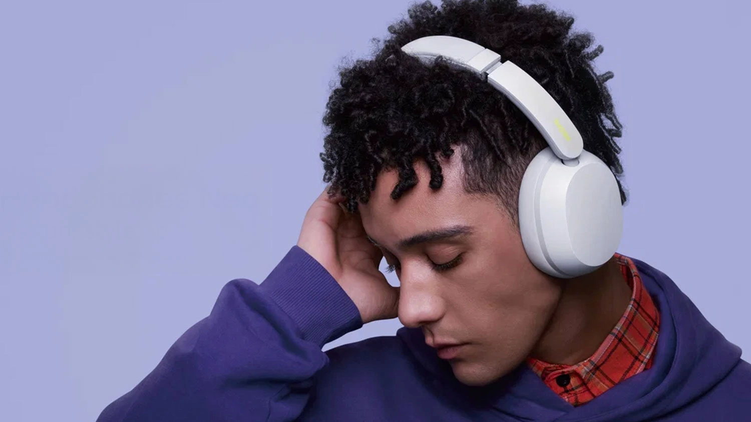 Mladý muž s nasazenými bílými bezdrátovými sluchátky Xiaomi REDMI Headphones Neo.