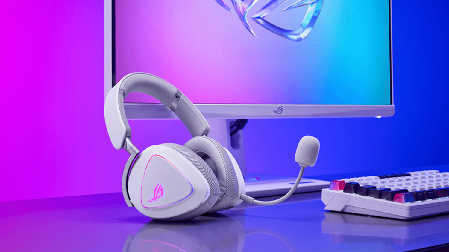 Hern&eacute; sl&uacute;chadl&aacute; Asus ROG Delta II biela na stole s monitorom a kl&aacute;vesnicou