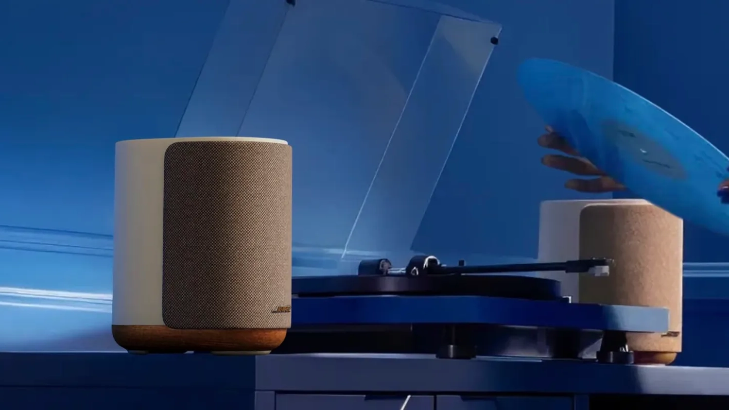 Ruky s platňou pri gramof&oacute;ne a reproduktoroch BOSE