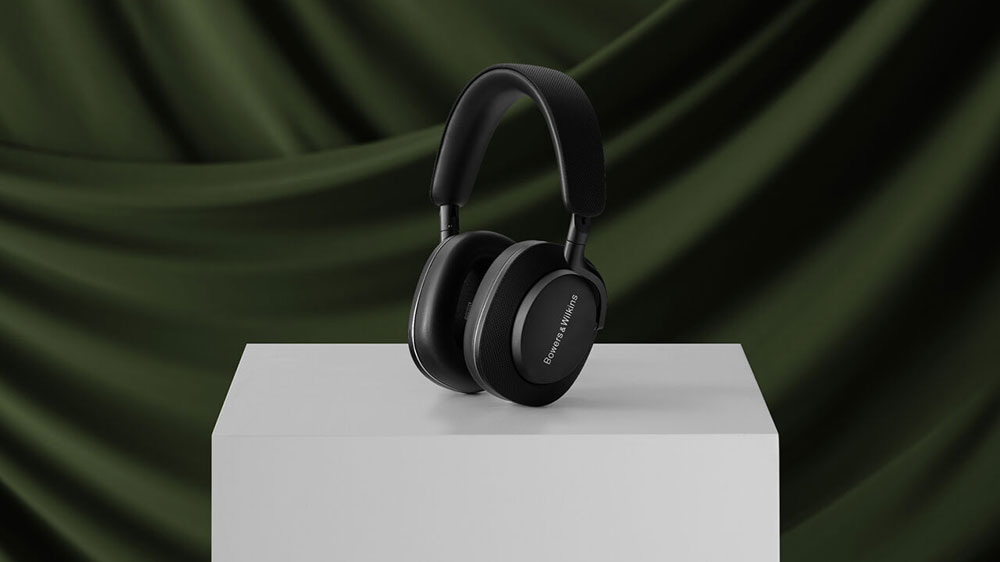 Muž sedící na gauči a má na hlavě bezdrátová sluchátka Bowers & Wilkins PX7 Tan_03