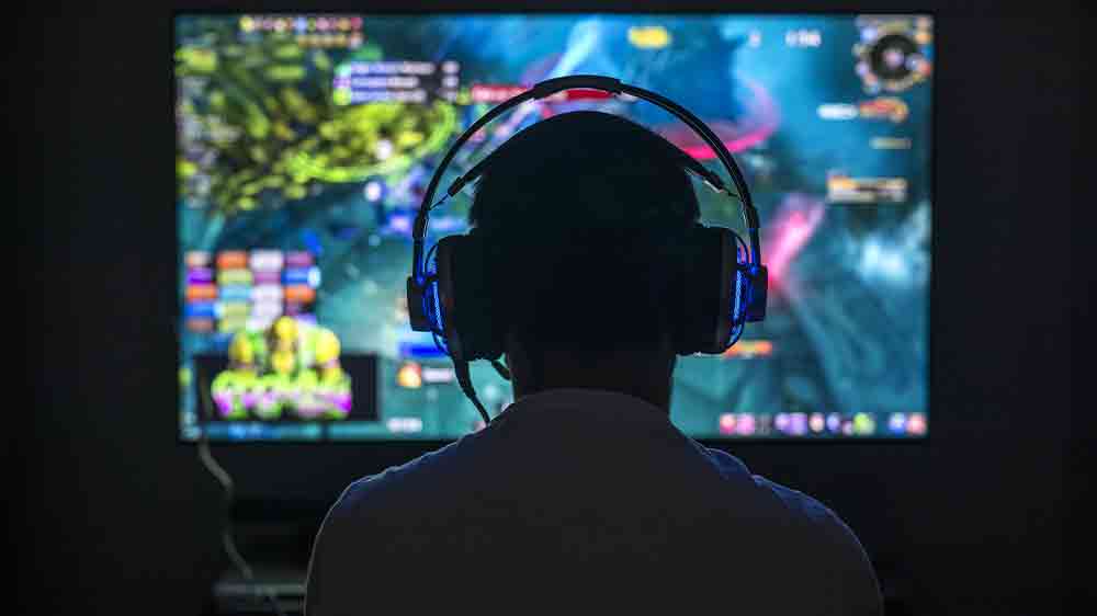 Muž se sluch&aacute;tky před monitorem_02