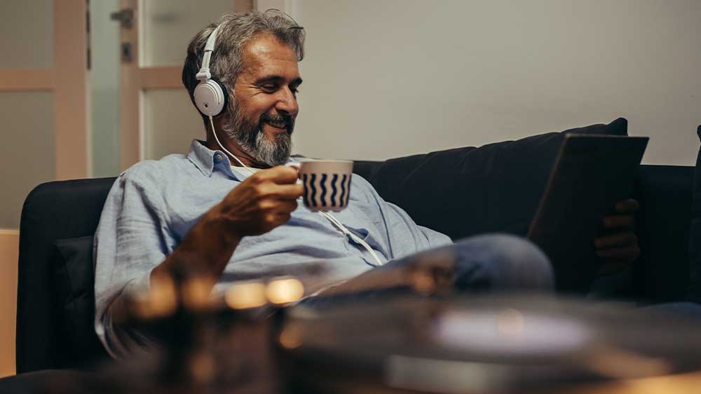 Starší muž poslouchá rádio přes sluchátka_03