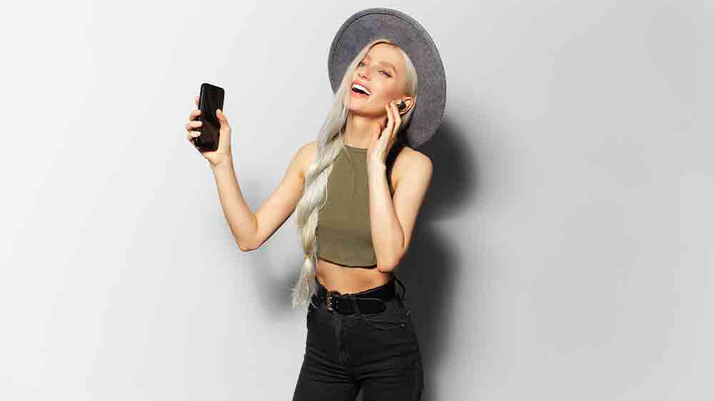 Žena se sluchátky poslouchá hudbu s mobilem v ruce_02