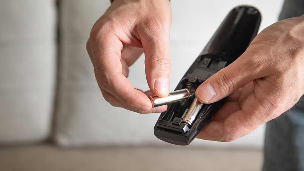 Muž vkládá baterie do dálkového ovladače_02