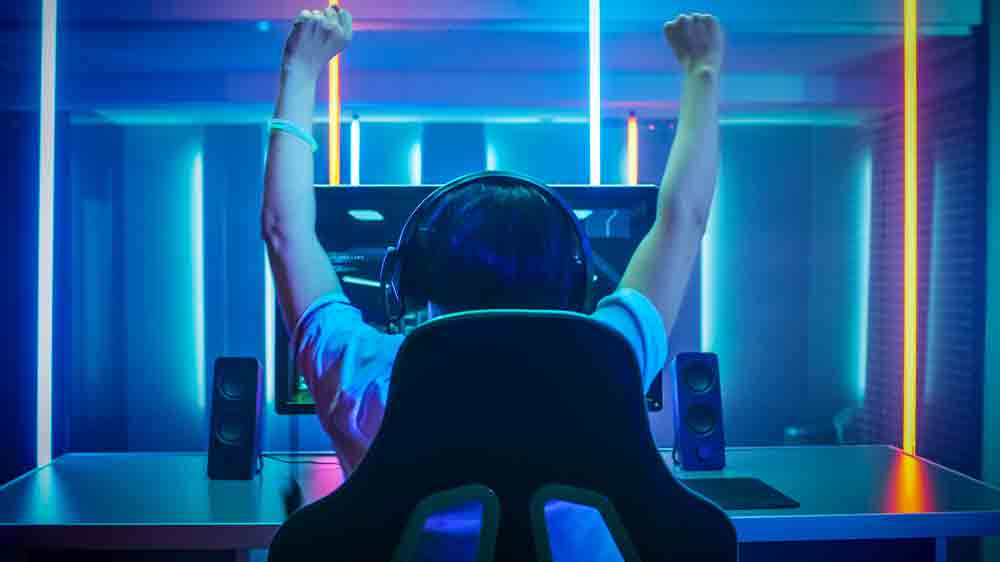 Hr&aacute;č se sluch&aacute;tky u monitoru_02