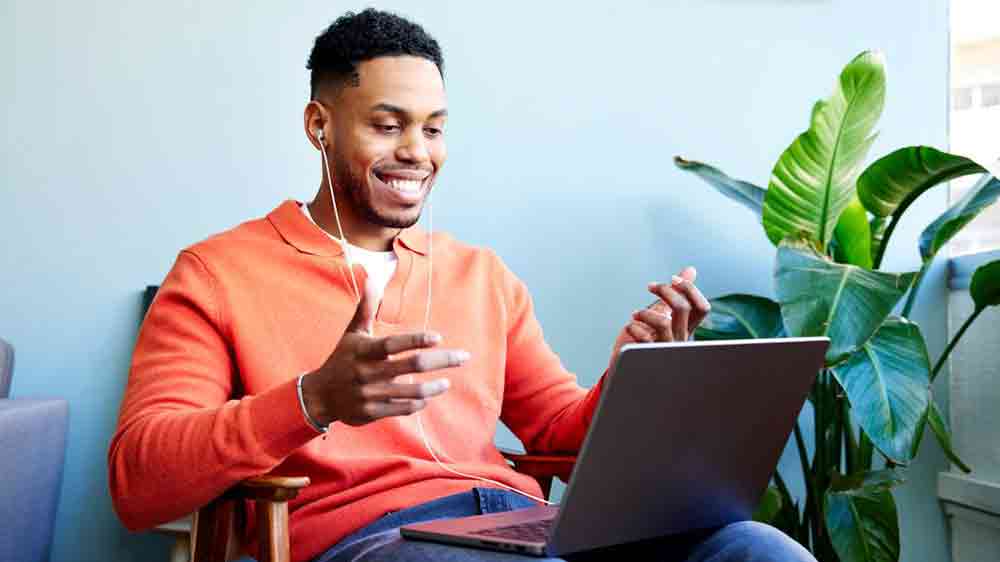 Muž se sluchátky připojenými k notebooku_02