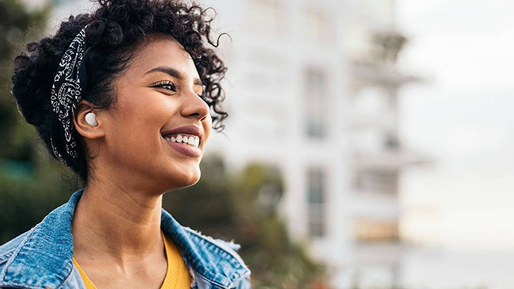 Mladá šťastná žena s bezdrátovými bílými sluchátky JBL Wave Buds 2_04