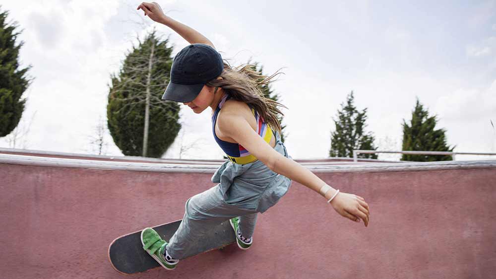 Dívka se sluchátky JBL Wave Flex na skateboardu_04