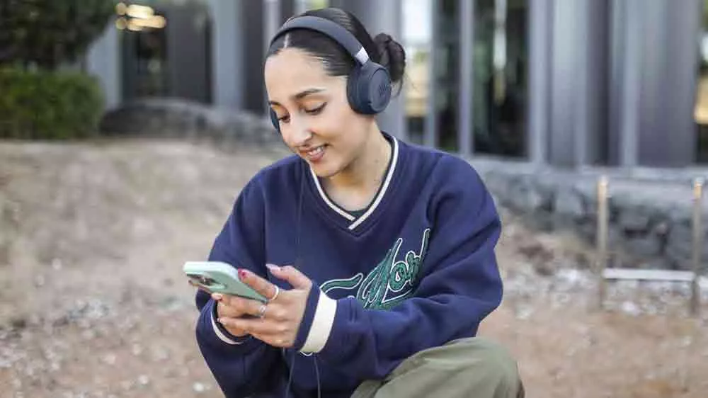 Žena venku se sluchátky JBL Tune 520C_04