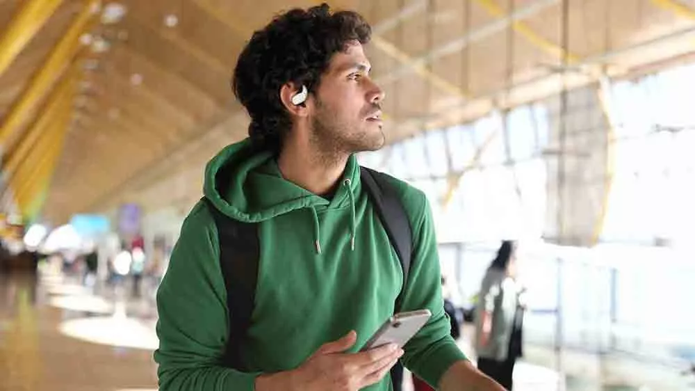 Muž vo vstupnej hale má na sebe športové bezdrôtové slúchadlá JBL Sense Lite_02