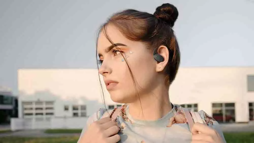 Mladá žena v přírodě s nasazenými sportovními sluchátky JBL Sense Lite_04