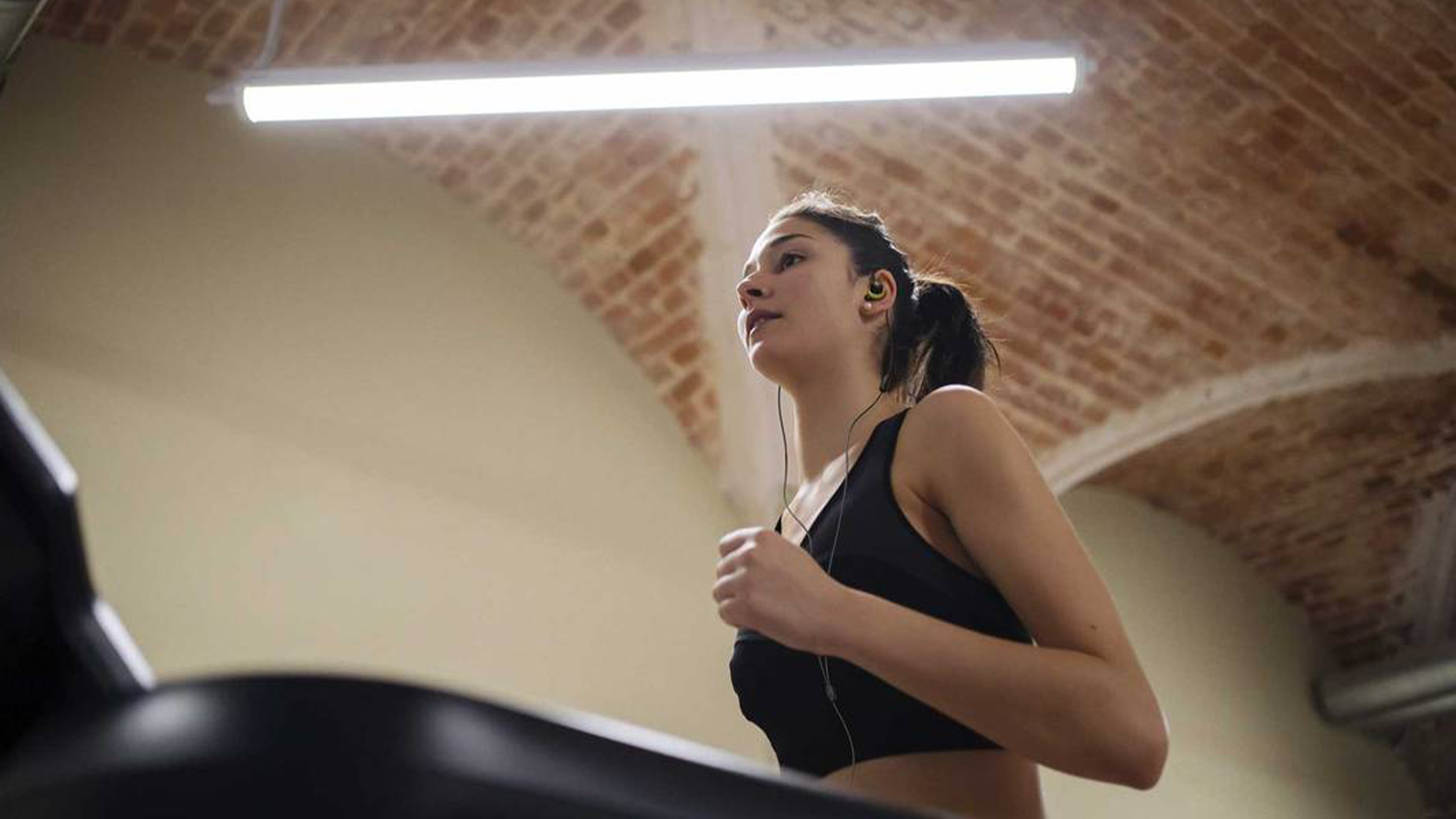 Žena v posilovně se sluchátky JBL Endurance Run 3