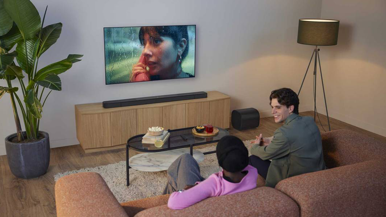 Ľudia sledujú televíziu, ku ktorej je pripojený soundbar JBL