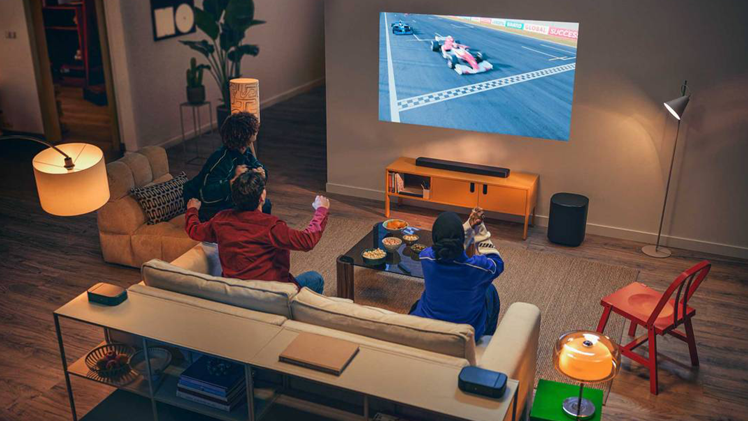 Ľudia pred telev&iacute;zorom, na ktor&yacute; je napojen&yacute; soundbar JBL