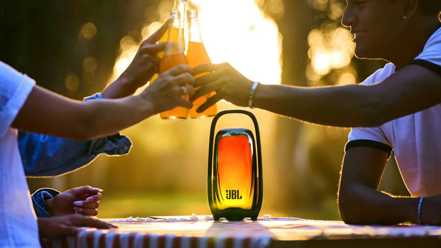 Lidé připíjející si u reproduktoru JBL Pulse 6