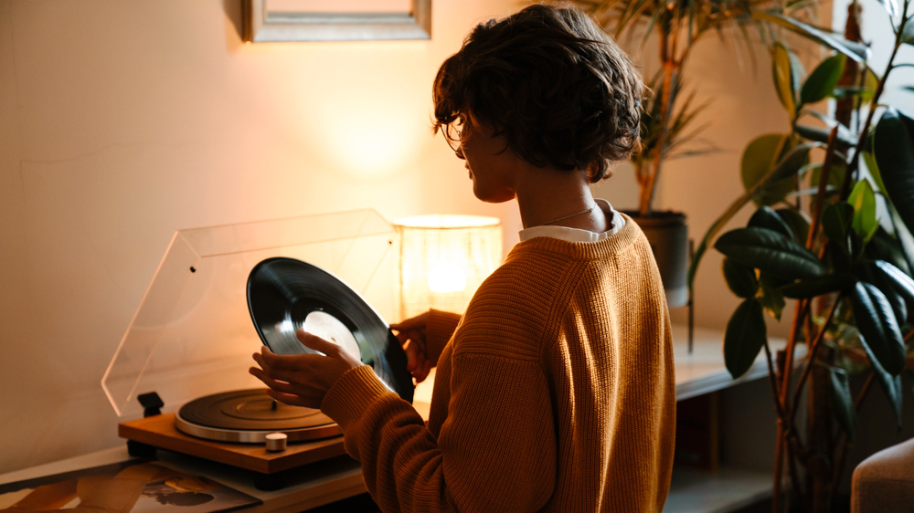 Žena pouštějící vinyl desku na gramofonu_02