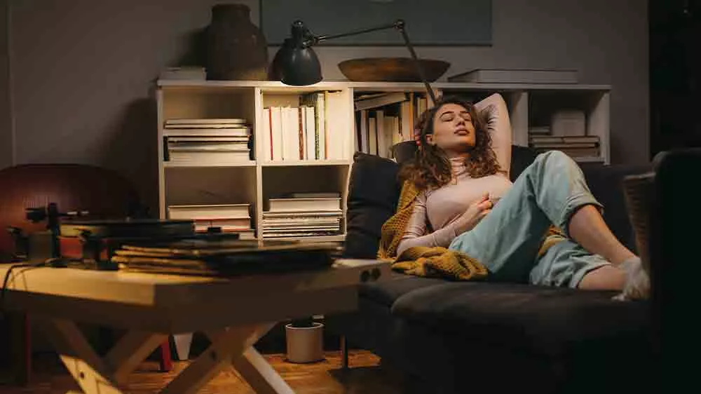 Žena leží na gauči a počúva hudbu z gramofónu