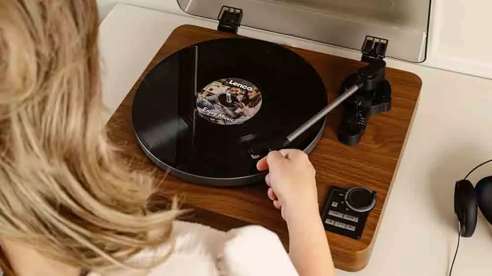 Žena polož&iacute; rameno gramof&oacute;nu Lenco LP na dosku