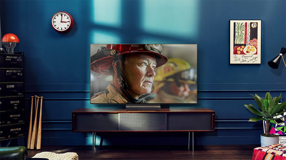 Interiér obýváku v retro stylu, dominujicí OLED Televize LG OLED65A23LA s obrazem hasiče