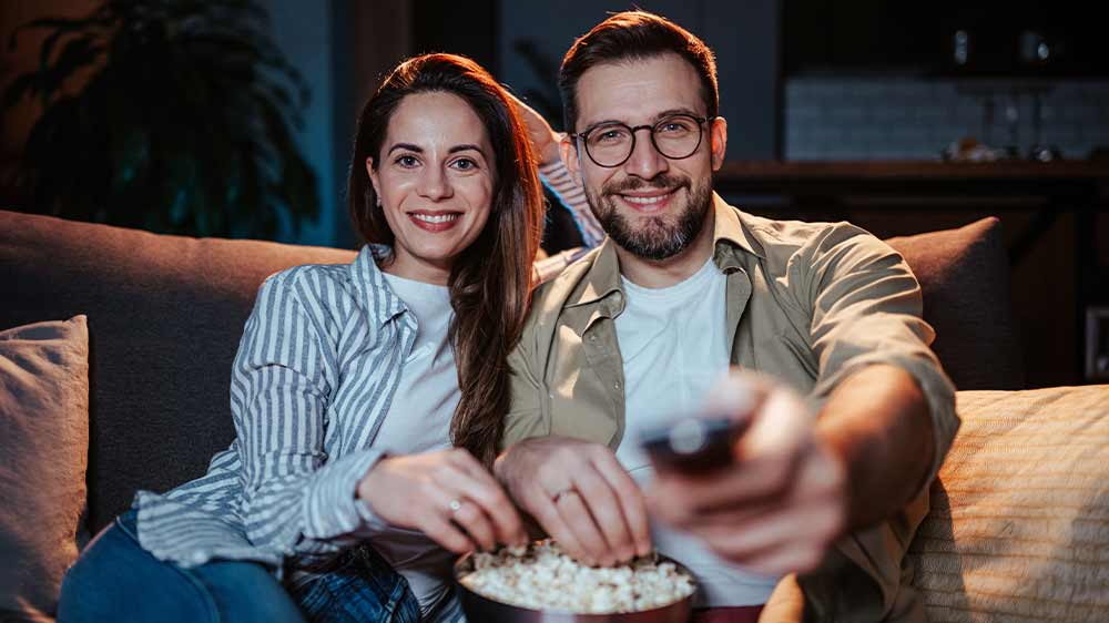Pár sledující televizi s popcornem_04