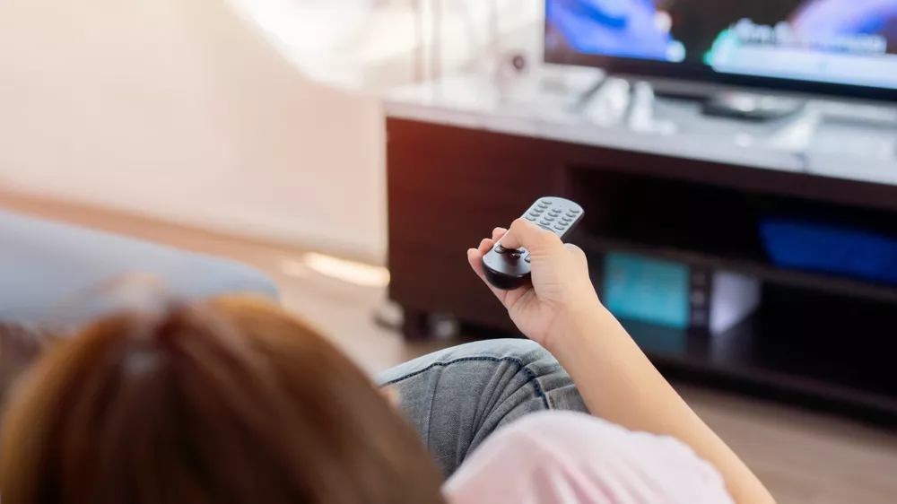 Žena m&iacute;ř&iacute;c&iacute; ovladačem na televizi_02