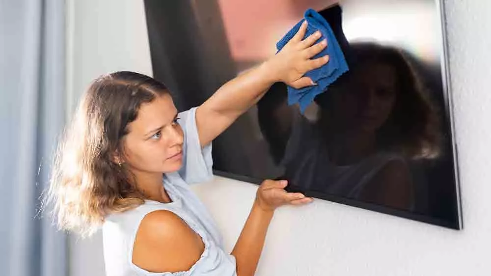 Žena čist&iacute; obrazovku televize v ob&yacute;vac&iacute;m pokoji_02