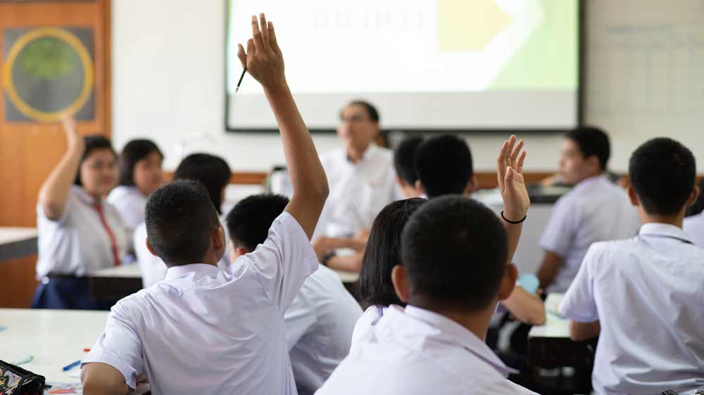 Hlásící se žák s projekčním plátnem na pozadí _03